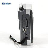 Side view of KCHIBO KK-9803 shortwave radio showing volume control, earphone jack, and wrist strap