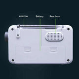 Back view of compact AM FM alarm clock radio showing antenna, battery compartment, and rear horn speaker