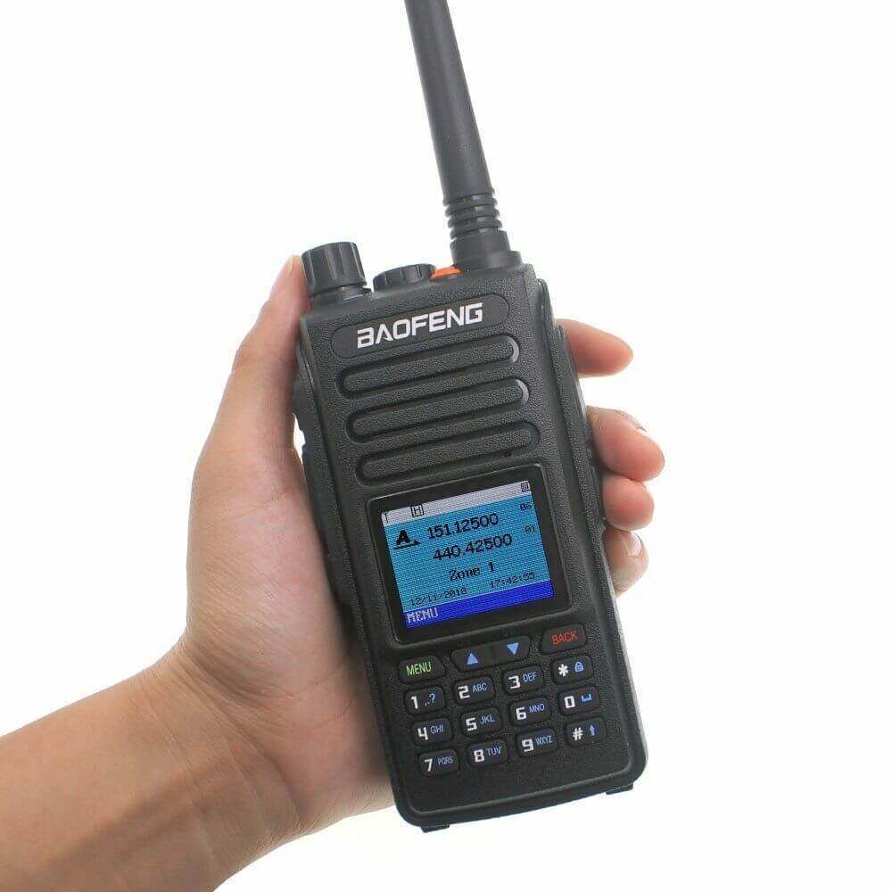 Hand holding Baofeng DM-1702 DMR radio with antenna and keypad visible on screen