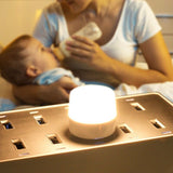 USB LED mini night light on bedside table illuminating a mother feeding her baby at night